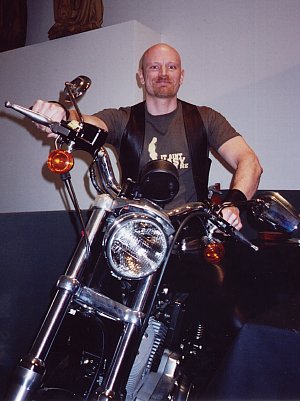 John sitting on his Harley Davidson at the Leather Archives and Museum, February 2004
